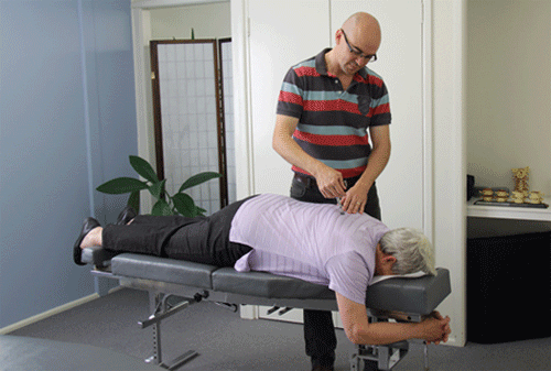Chiropractor Dr David Malone using the Activator to adjust a client
